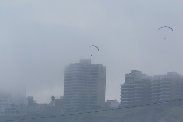 Paragliders over Miraflores and fog