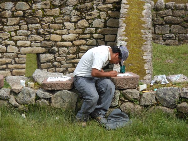 Worker painting signs at Machu Picchu